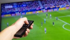 Una persona viendo el fútbol en la televisión.