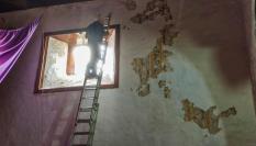 Un operario pinta sobre los frescos de la parroquia de San Antonio de Padua, en El Tanque