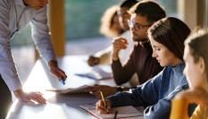 El profesor corrigiendo un ejercicio a sus alumnos.