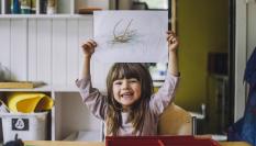 Imagen de archivo de una niña con un dibujo.