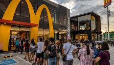 Clientes de McDonald's hacen cola en la entrada de un restaurante de la cadena de comida rápida.