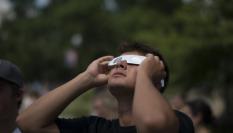 Un hombre dirige su mirada hacia el sol, protegido con unas gafas especiales, en un eclipse solar