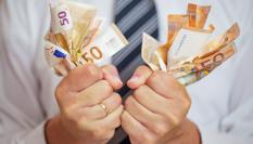 Un hombre agarrando billetes de 50 euros.