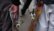 Imagen de dos patinadores con sus tablas.