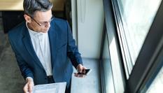 Imagen de un ejecutivo comprobando un mensaje en su teléfono móvil.