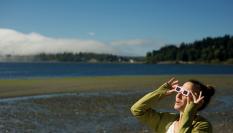 Una mujer con gafas de sol mira un eclipse.
