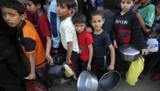 Imagen de archivo de varios niños gazatíes haciendo cola para recibir comida de la escasa ayuda humanitaria que ha logrado llegar a la Franja.