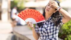 Una mujer abanicándose por el calor.