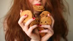 Mujer comiendo galletas.