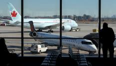 Una persona observa un avión de Air Canadá en el Aeropuerto Internacional Pearson de Toronto.