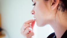 Una mujer tomando un medicamento.