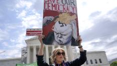 Una mujer protesta ante el Tribunal Supremo de los EEUU con un cartel contra Donald Trump.
