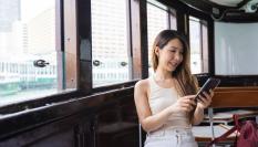 Imagen de archivo de una mujer comprobando su 'smartphone' en un barco.