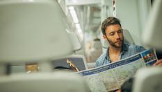 Un turista consulta un mapa de de España mientras viaja en tren.