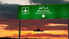Ilustración de la silueta de un avión volando hacia Marrakech (Marruecos) en el horizonte.