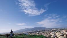 Un hombre con carretilla observa Melilla desde el Monte Gurugú, en Marruecos.