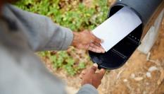 Hombre sacando una carta del buzon