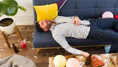 Imagen de archivo de un hombre tumbado en un sofá tras demasiada fiesta.