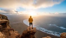 Persona admirando el atardecer en una playa de Lanzarote