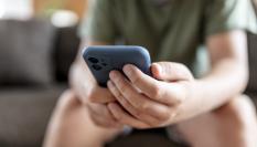 Imagen de archivo de un menor con un móvil en la mano.