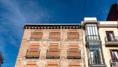 Antiguo edificio residencial con ventanas tapiadas para evitar la entrada de okupas.
