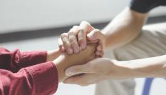 Una persona sosteniendo las manos de otra.