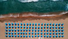 Imagen de archivo aérea de sombrillas en un arenal.