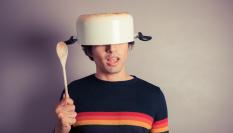 Imagen de archivo de una persona llevando una olla en la cabeza.