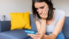 Imagen de una persona observando algo con preocupación en su teléfono móvil.