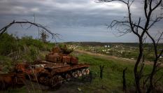 Los restos de un tanque ruso calcinado reposan junto a una carretera en Ucrania.