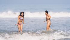 Dos mujeres entrando en el agua fría del mar.