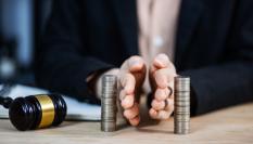 Imagen de archivo de una mesa con un mazo y unas manos dividiendo dinero.