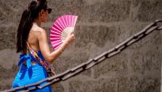 Imagen de archivo de una persona con un abanico, en las calles de Sevilla (Andalucía), en plena ola de calor.
