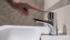 Imagen de archivo de una persona cortando el agua de un grifo.