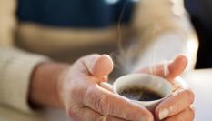 Una persona mayor con una taza de café.
