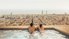 Una pareja se relaja en la azotea de un hotel de Barcelona mirando el skyline de la ciudad