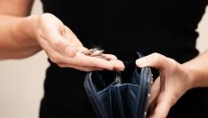 Imagen de archivo de una mujer comprobando el dinero de su monedero.