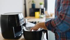 Un hombre usando una freidora de aire.