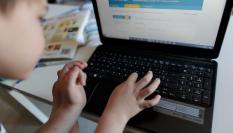 Un niño hace deberes del colegio en su ordenador