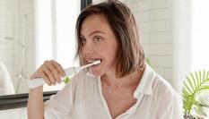 Una mujer lavándose los dientes.