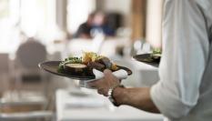 Un camarero sirve un plato en un restaurante.