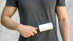 Un hombre cepilla su camiseta para quitar los pelos de su mascota.