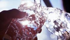 Un vaso llenándose con agua del grifo.