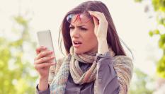 Una persona observa algo con preocupación en su teléfono móvil.