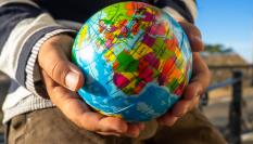 Un niño con la bola del mundo en las manos.