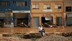 Un hombre habla por teléfono en una calle inundada tras el paso de la DANA por Valencia.