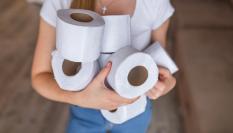 Imagen de una persona sosteniendo rollos de papel higiénico.