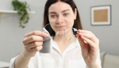 Imagen de una persona limpiando los cristales de las gafas.