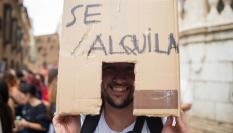 Un manifestante lleva una caja que representa una casa en alquiler en una manifestación en Málaga exigiendo una vivienda digna.
