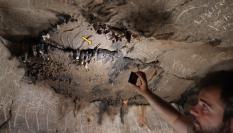 El investigador Xabier Garín Artázcoz señala el lugar exacto de la cavidad en el que se halló la moneda romana de la época del emperador Claudio